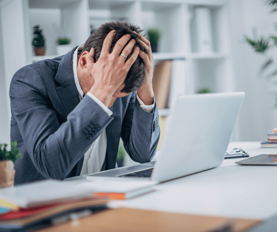 Persona estresada frente a su computadora por problemas de gestión